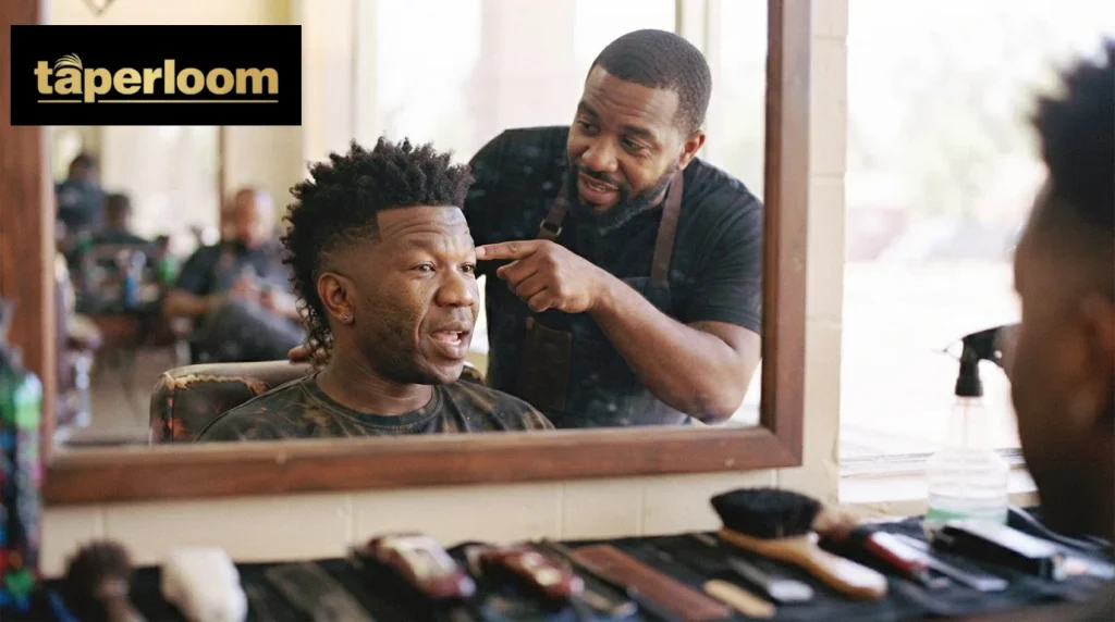 Barber showing a client a burst fade design placement in the mirror